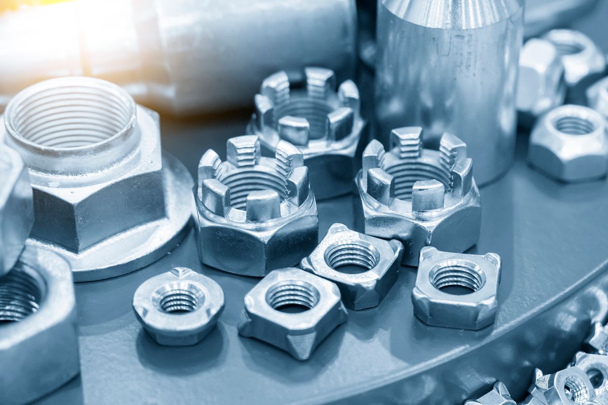 Hay muchos tipos diferentes de tuercas y tornillos sobre la mesa.