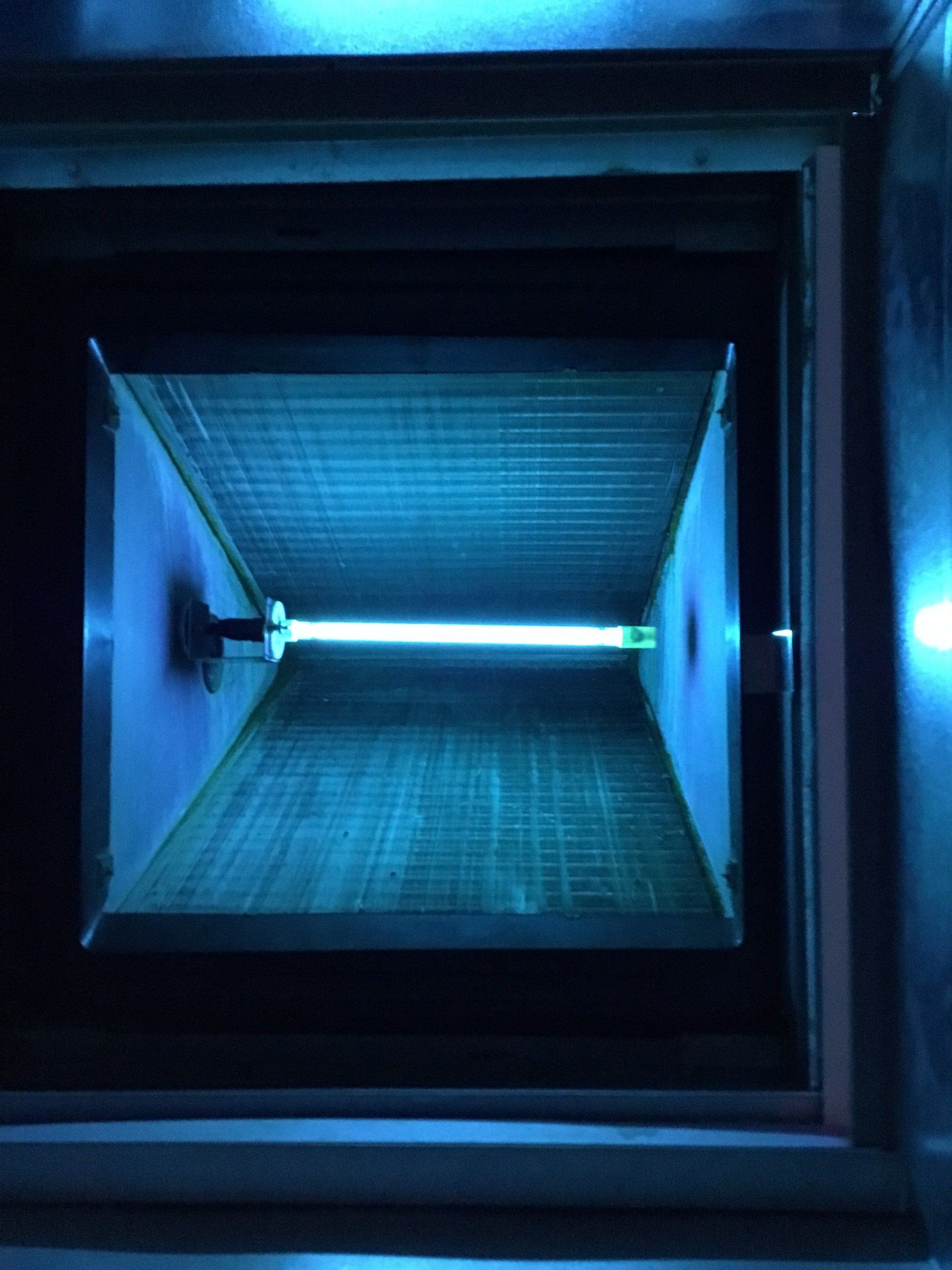 A blue light is shining through a window in a room.