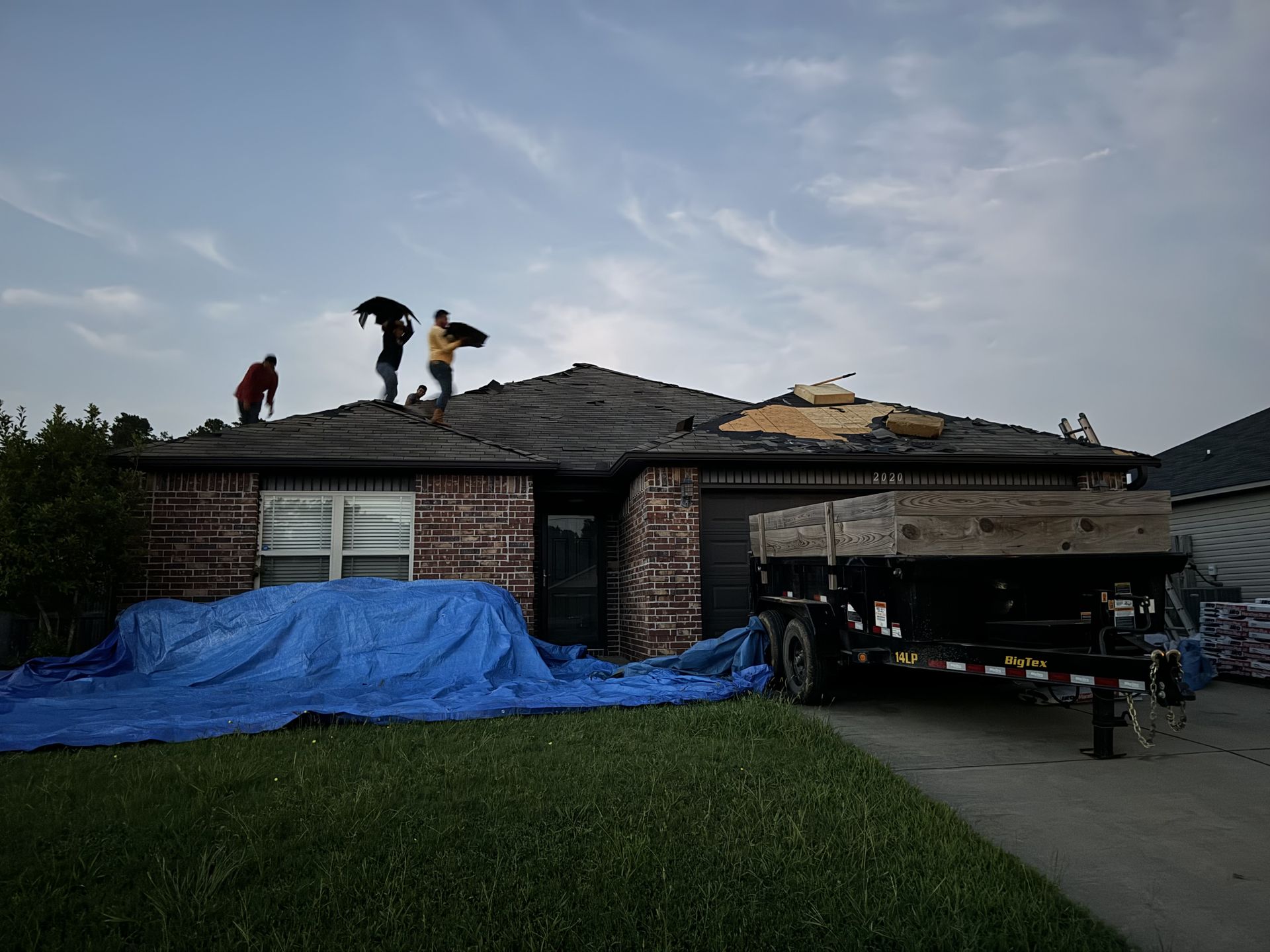 Two men are working on the roof of a house.