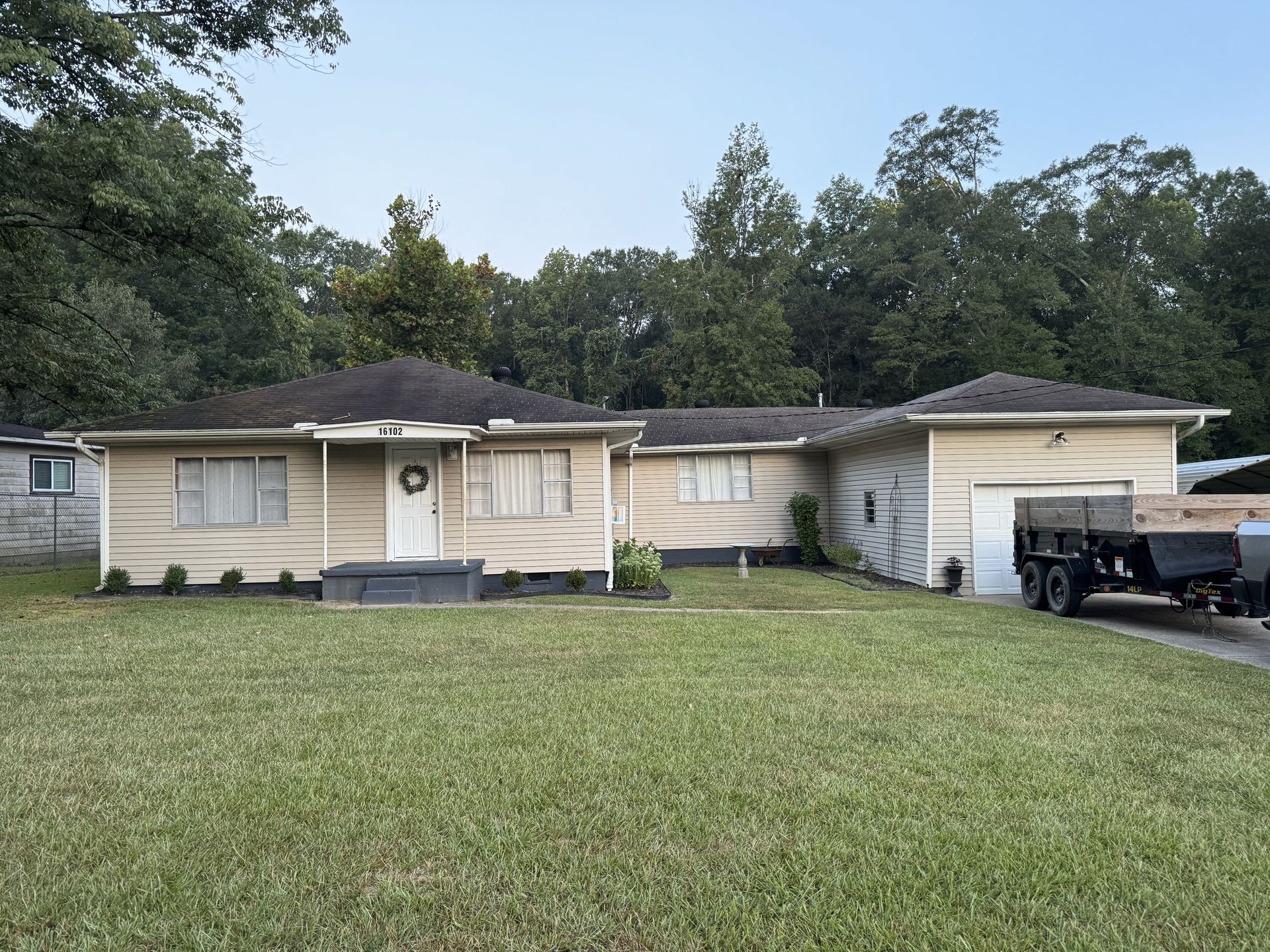 A house with a trailer parked in front of it