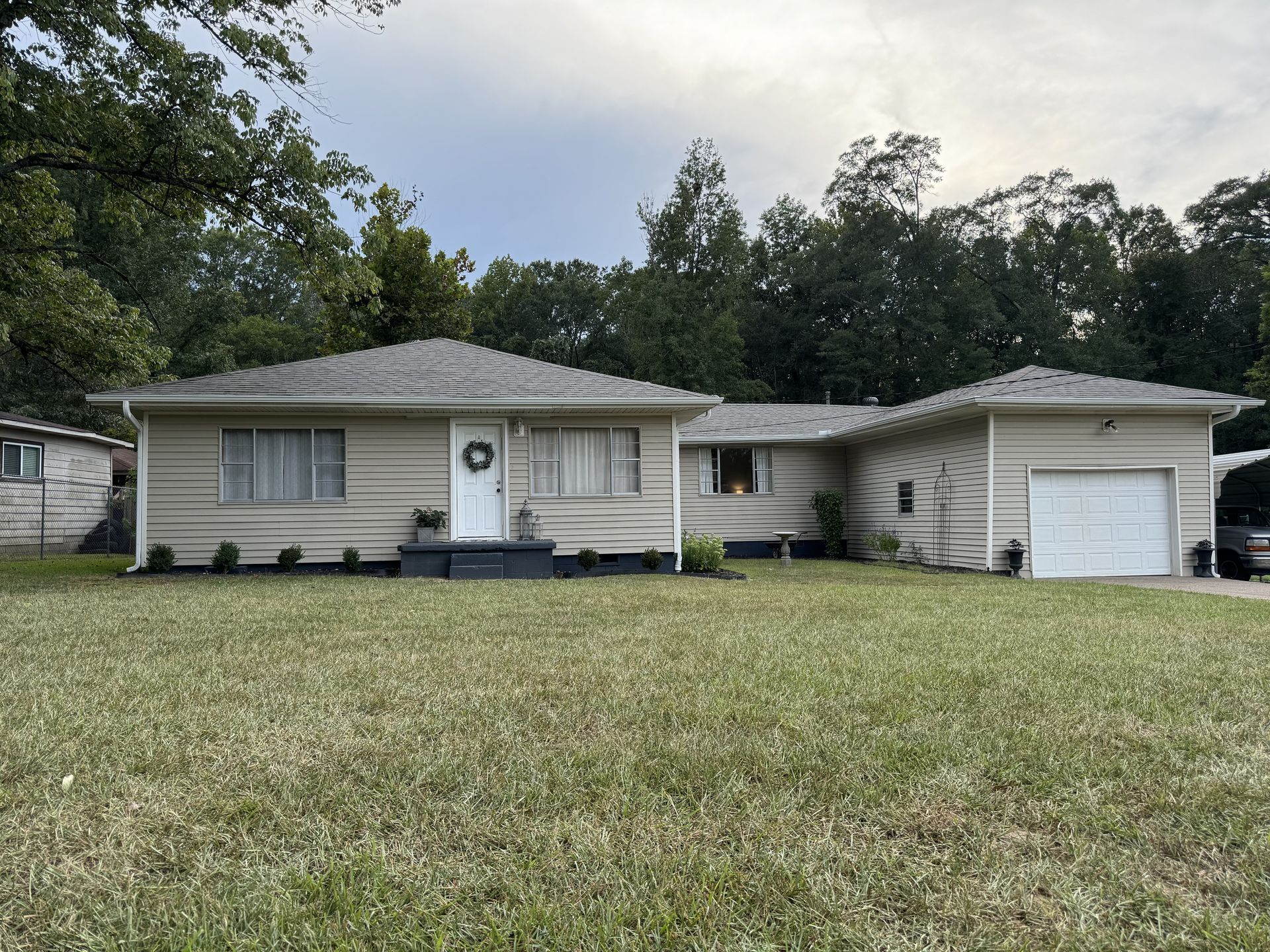 A house with a large lawn in front of it and a garage.