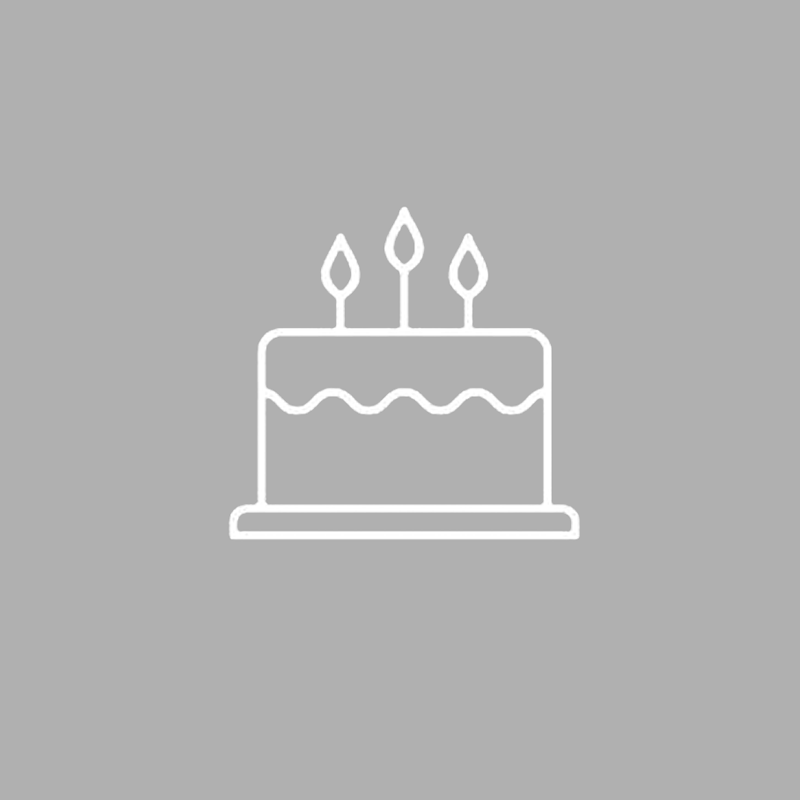 A white line icon of a birthday cake with three candles on a gray background.