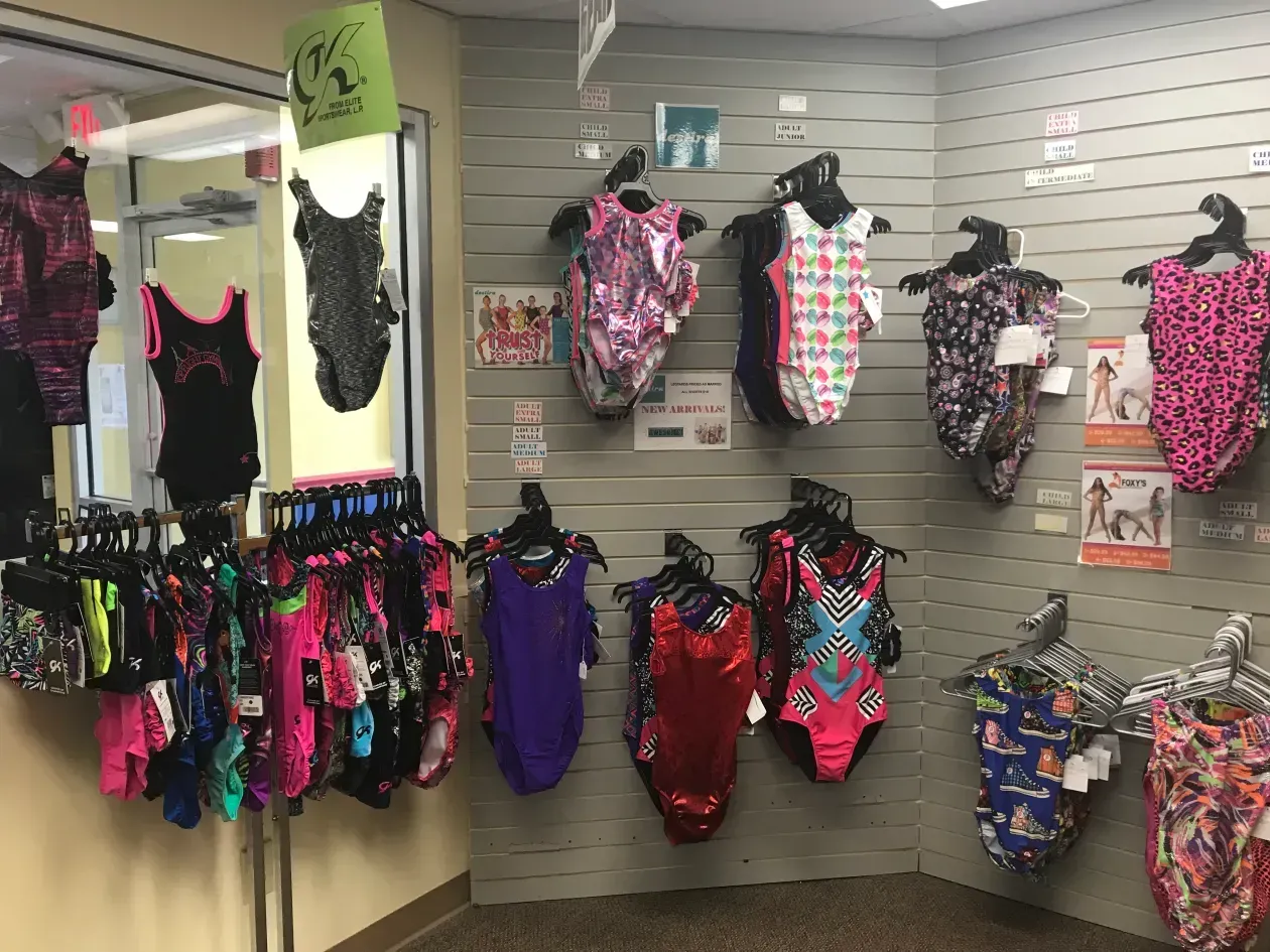 A bunch of swimsuits are hanging on a wall in a store.