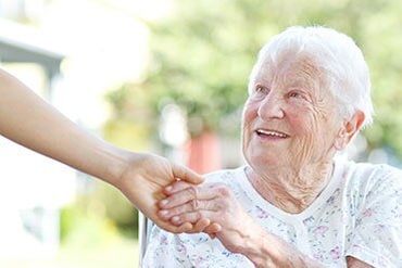 Assisted Living Home — Senior Citizen Holding Caregiver's Hand in Central City, NE