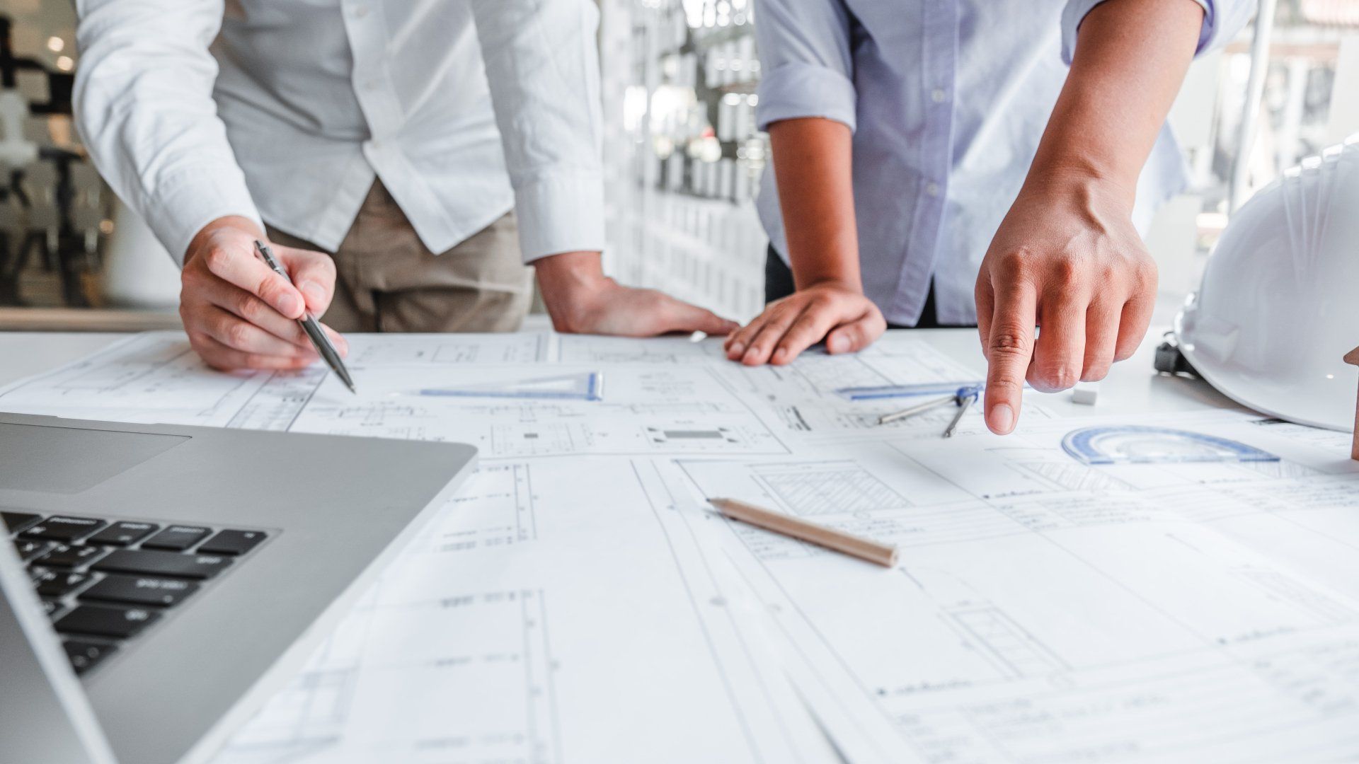A group of people are looking at a blueprint on a table.