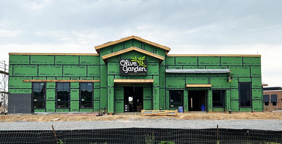 A building under construction with a sign that says olive garden