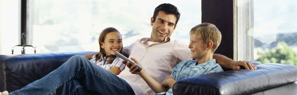 Family watching a home theatre system in Waihi