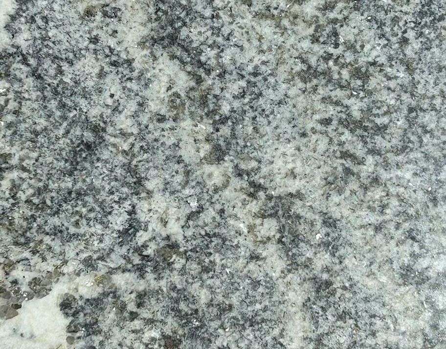 A piece of granite is sitting on top of a concrete surface.