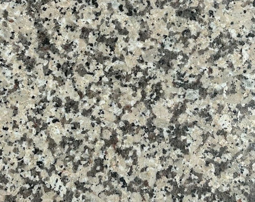 Three pieces of granite are sitting on a concrete surface.