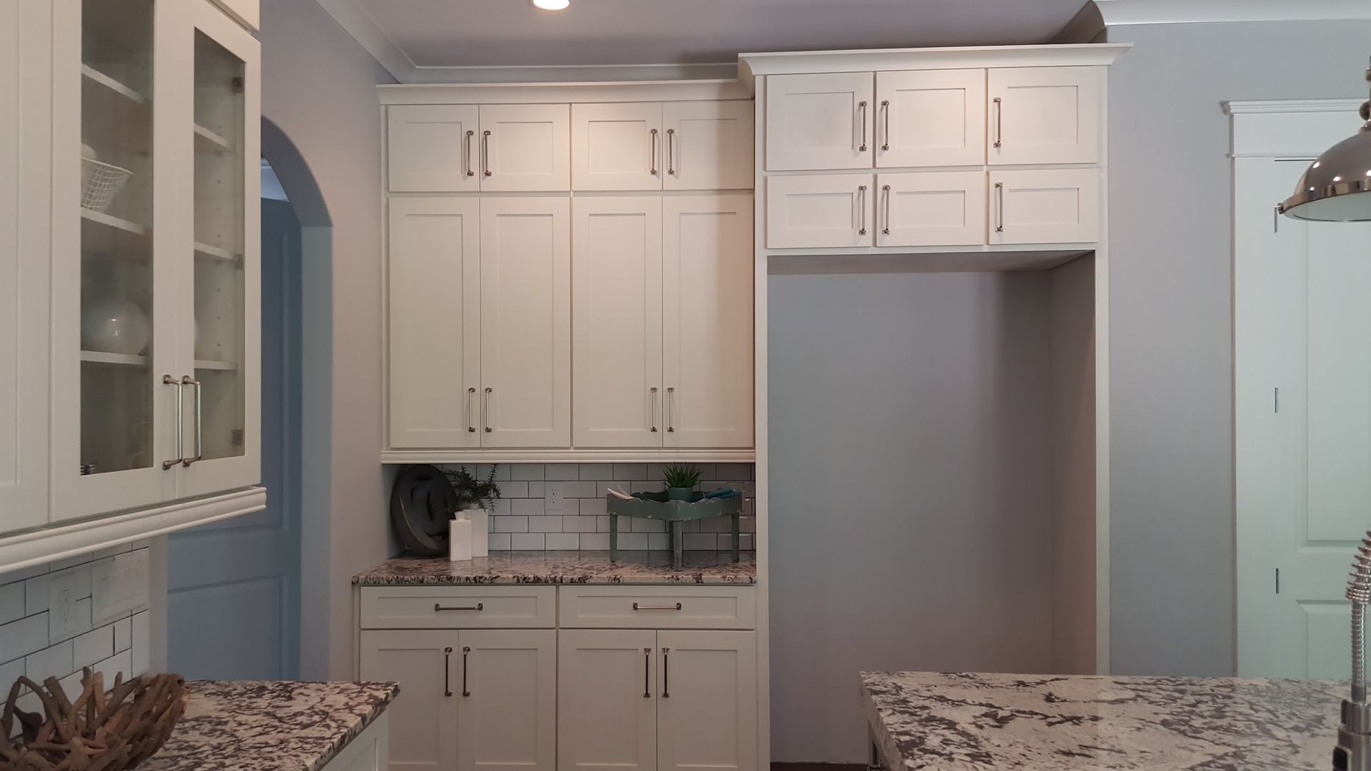 White kitchen with cabinets, countertop, and refrigerator space.