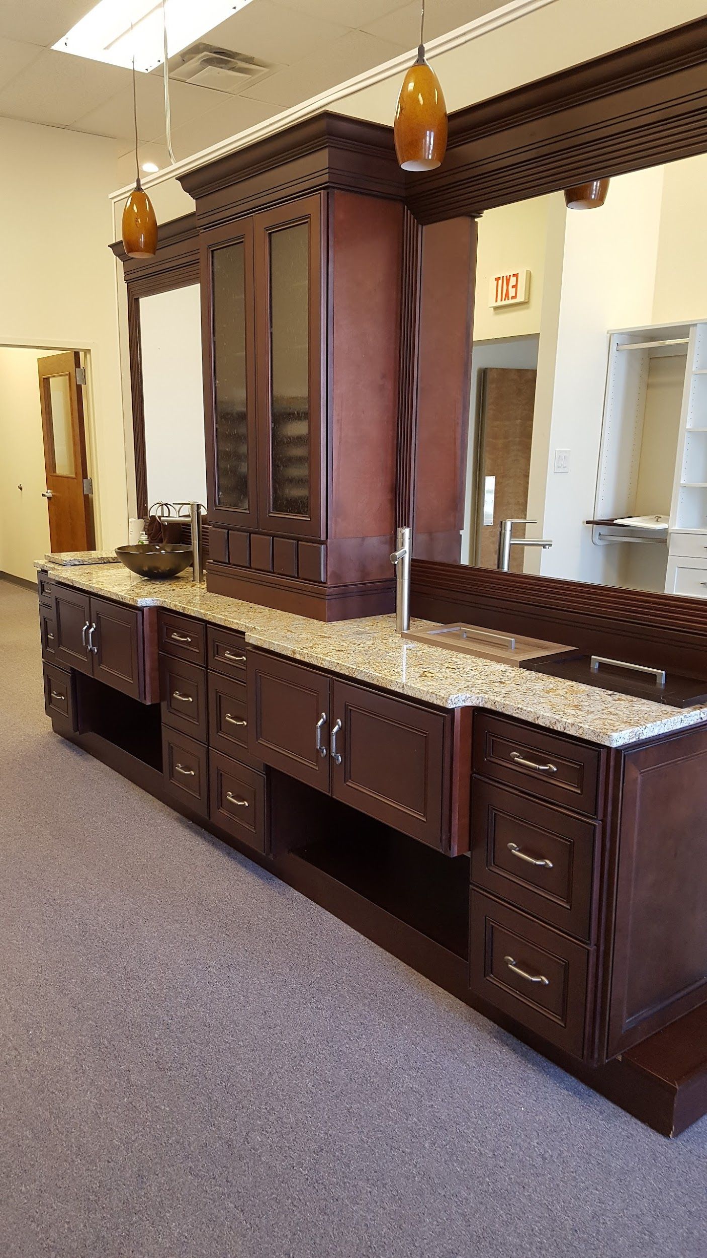 Dark wood vanity with granite countertop and built-in cabinets in a room with white walls.