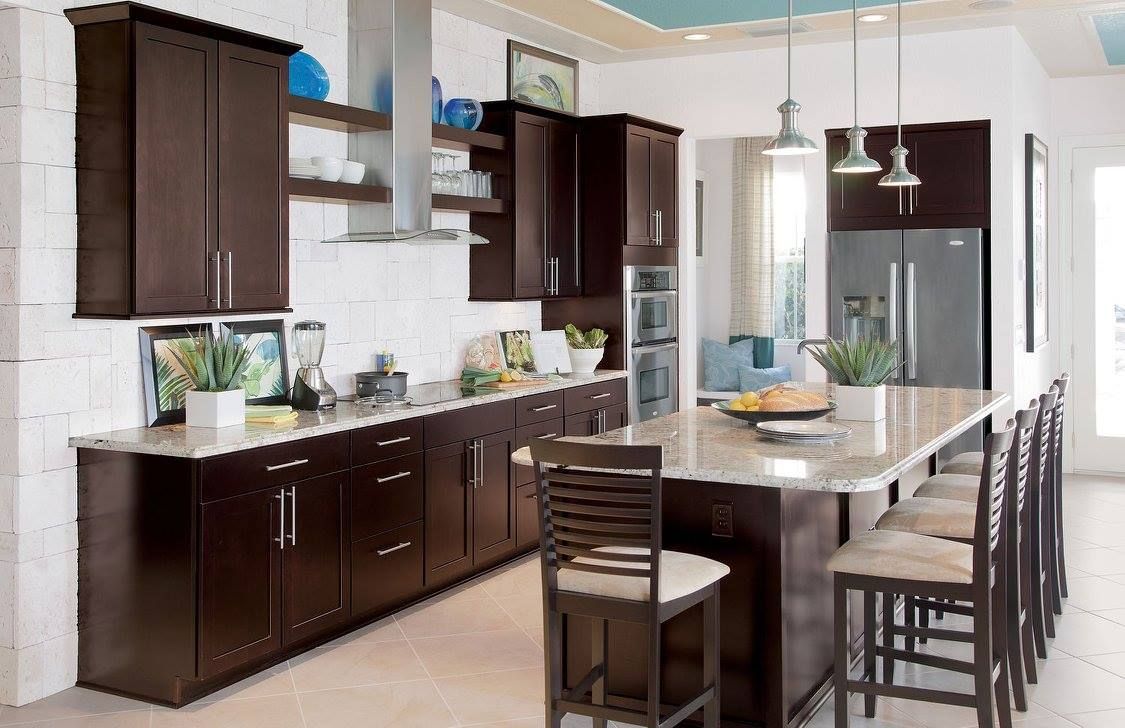 Dark-brown kitchen with island and cabinets, white countertops, stainless steel appliances, and turquoise ceiling.
