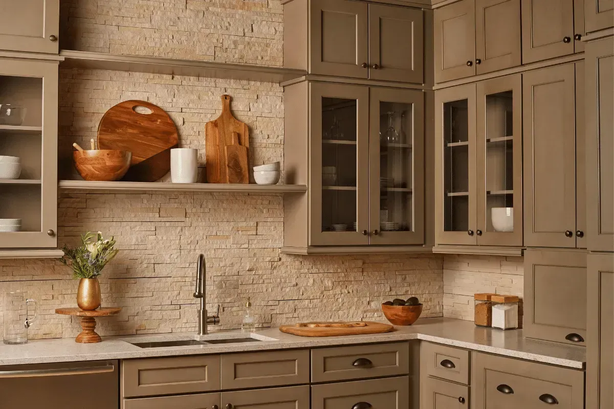 Kitchen with beige cabinets, stone backsplash, and wooden shelves displaying bowls and cutting boards.