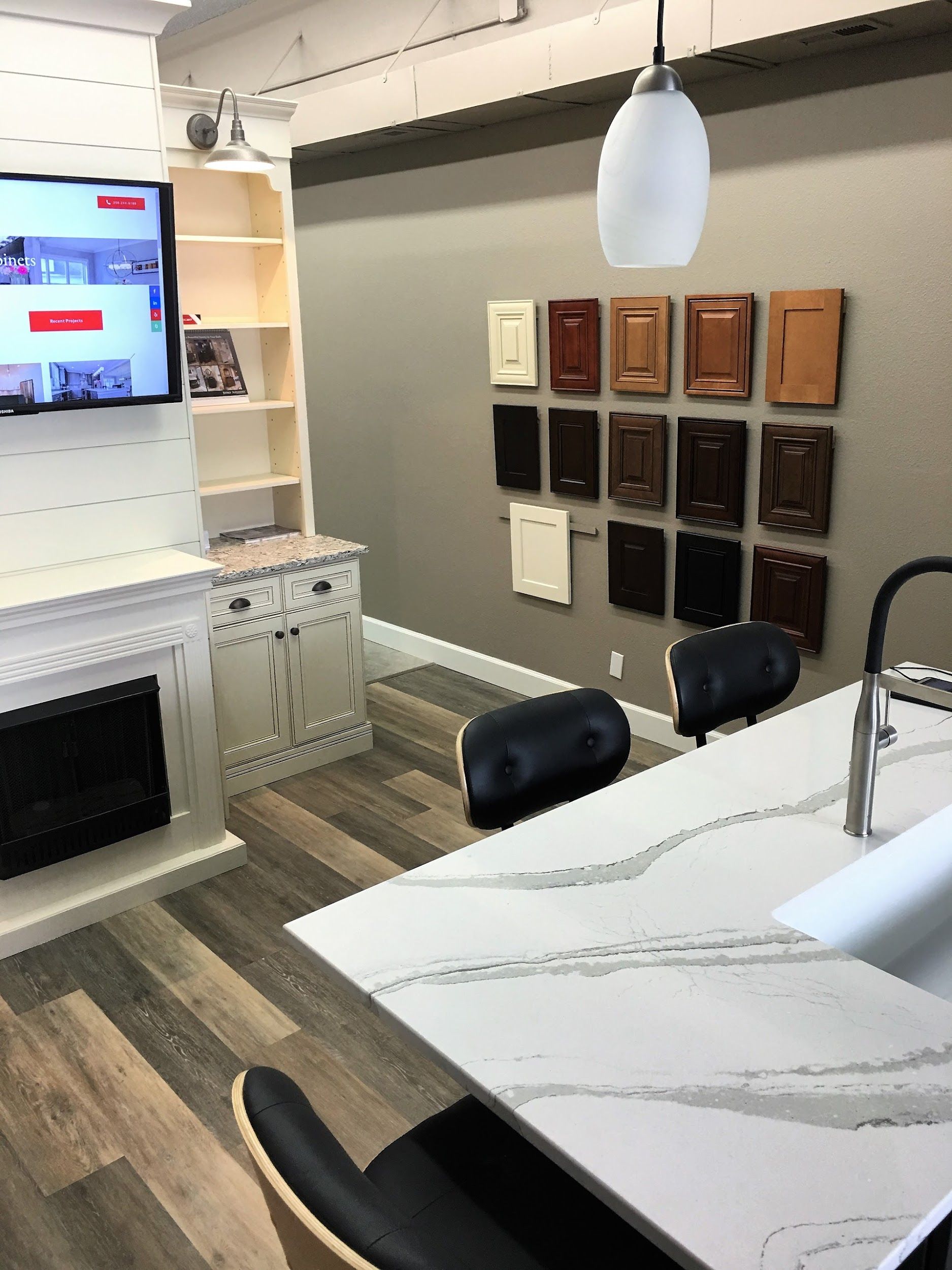 Kitchen display with cabinets, countertop, fireplace, and a TV.