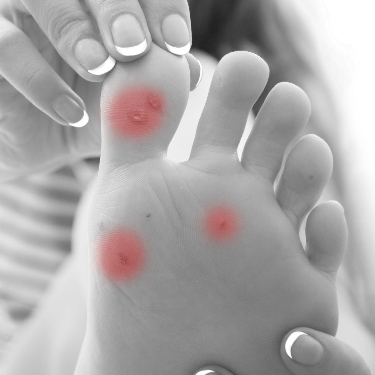 A person wearing blue gloves is examining a person 's foot.