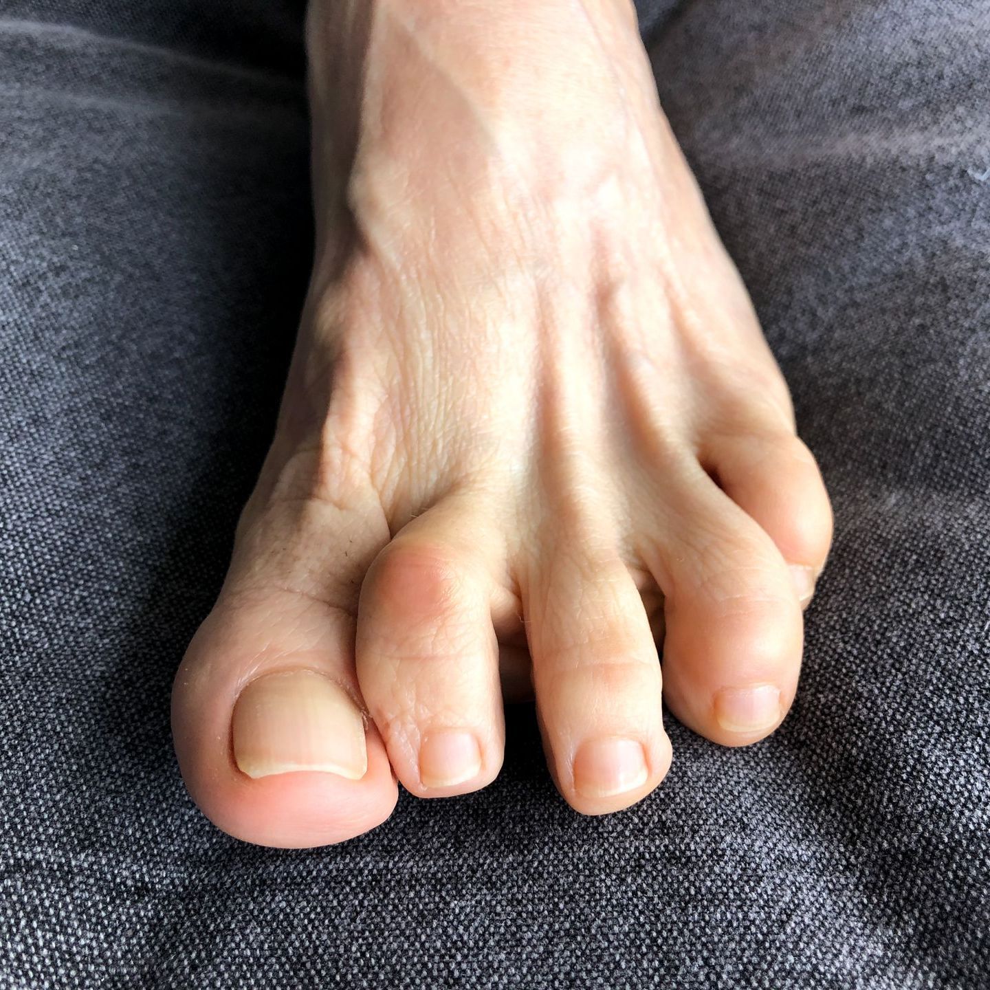 A close up of a person 's feet on a couch.