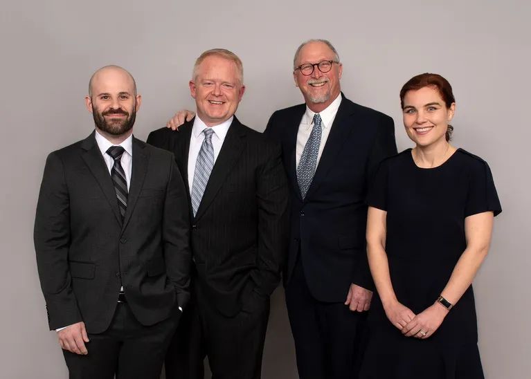 A group of people in suits and ties are posing for a picture.