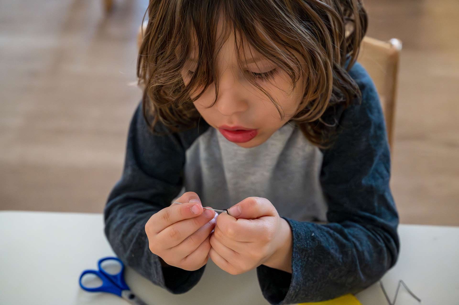 Montessori child focused on a learning activity with small objects