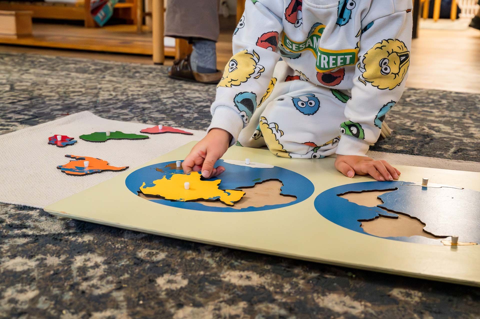 Montessori child working continent puzzle map