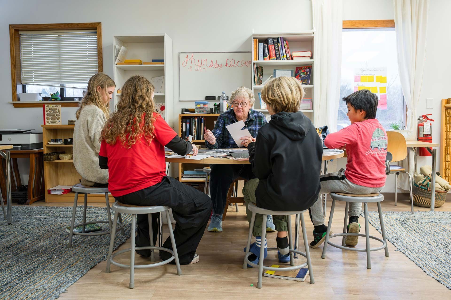 Montessori guide with montessori children in a classroom setting around a table