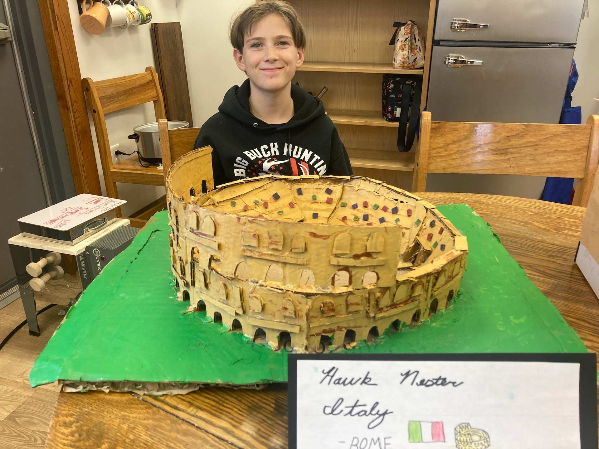 montessori child presenting model of colosseum in classroom setting