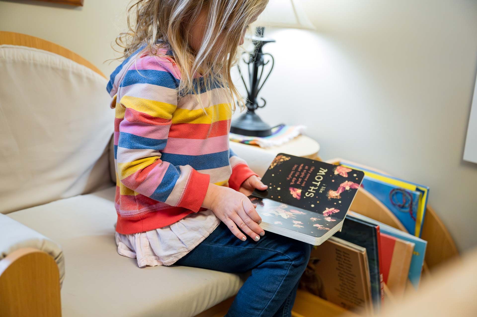 montessori child reading a book in a cozy classroom