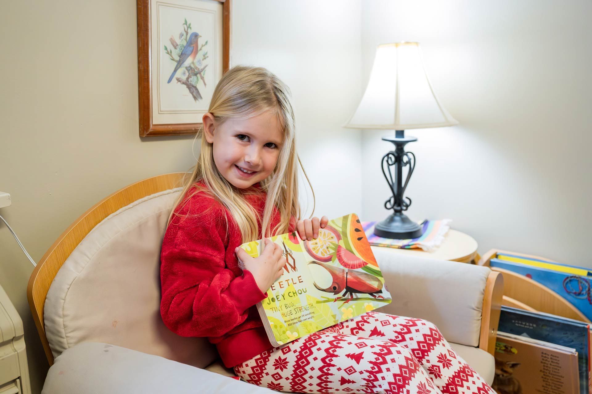 montessori child reading in a cozy nook with childrens books and soft furnishings