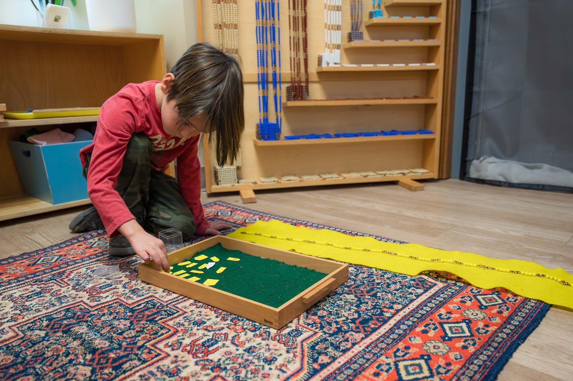 montessori child working with math materials on a rug