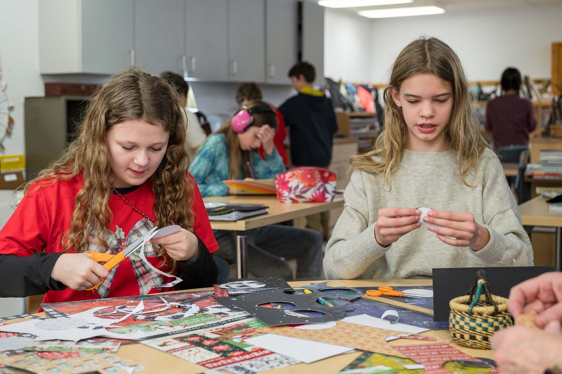 montessori children engaged in paper crafts at a classroom table