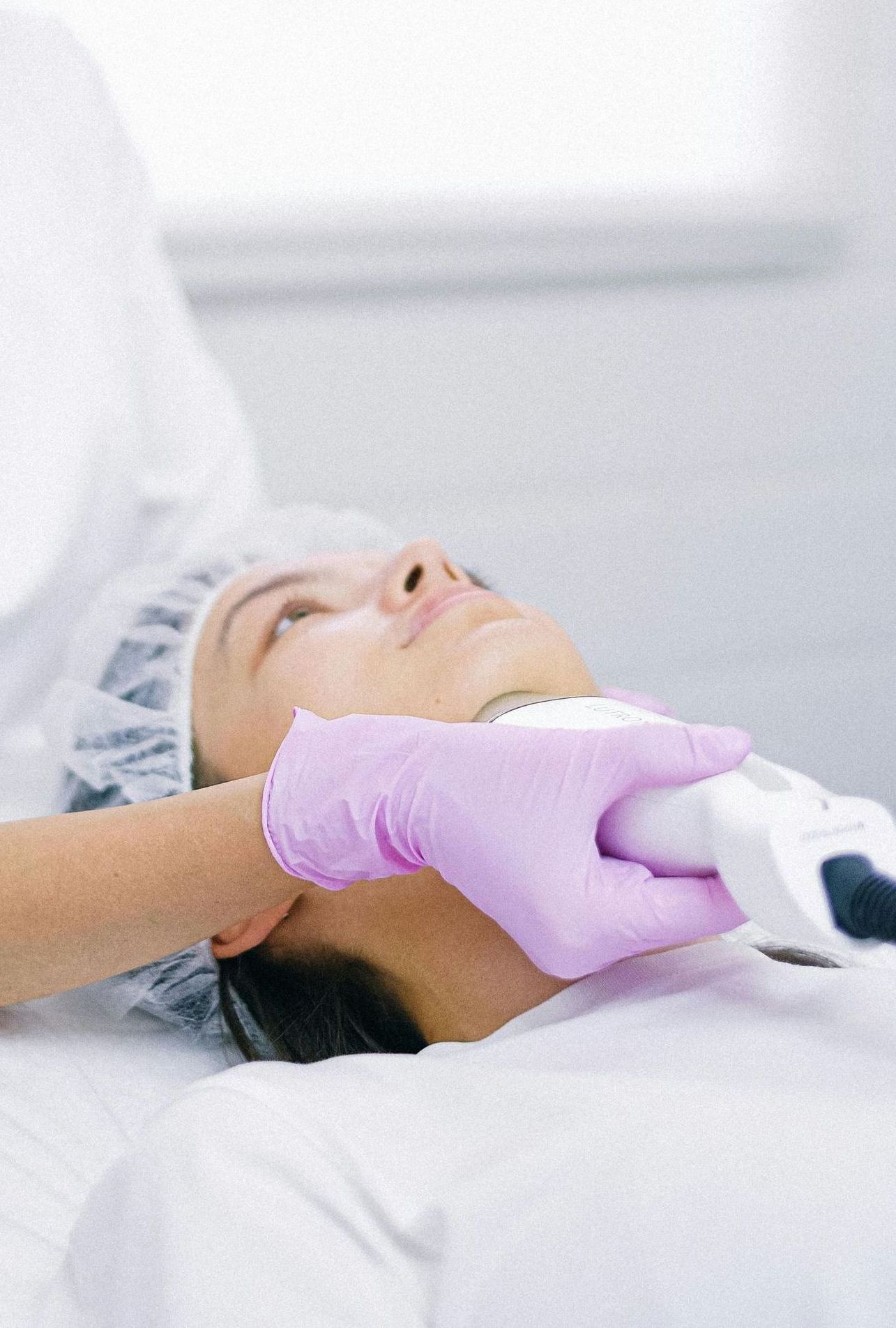 Una mujer le está dando a otra mujer un tratamiento facial en un salón de belleza.