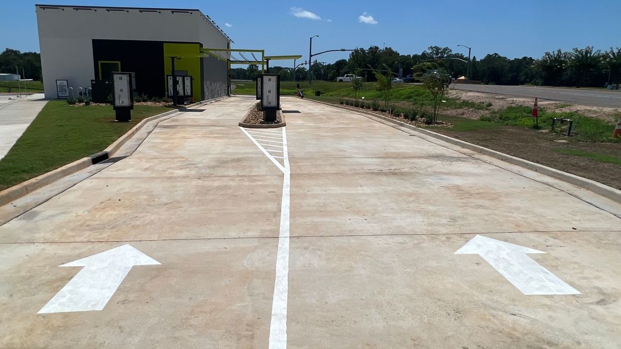 A concrete road with two white arrows pointing in opposite directions