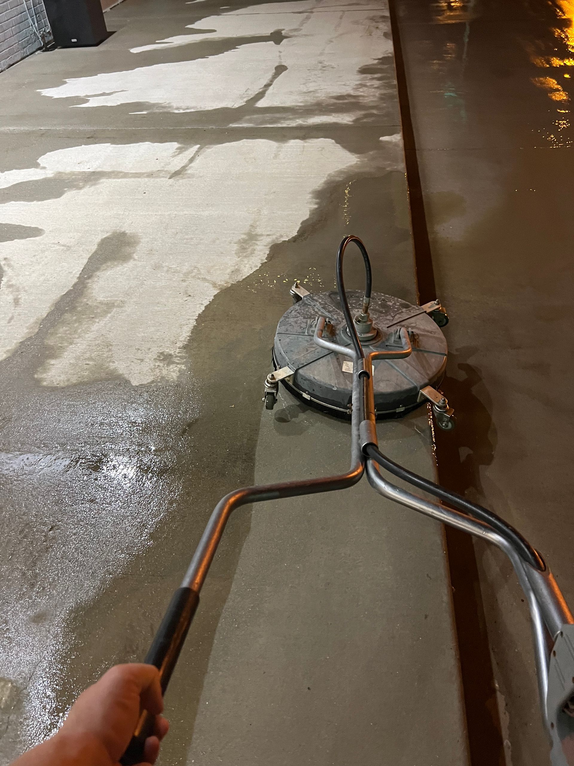 A person is using a machine to clean a concrete floor.