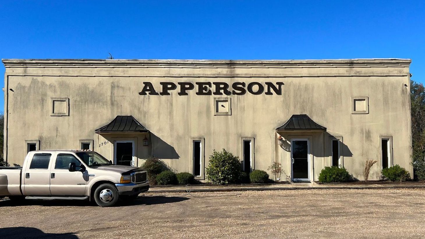 A truck is parked in front of a building that says apperson