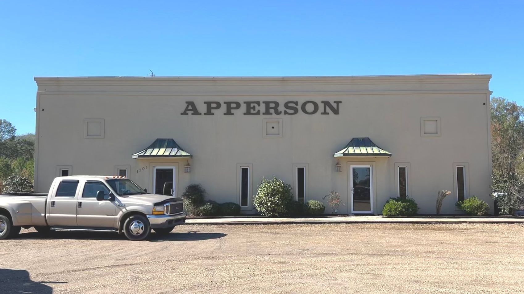 A truck is parked in front of a building that says apperson