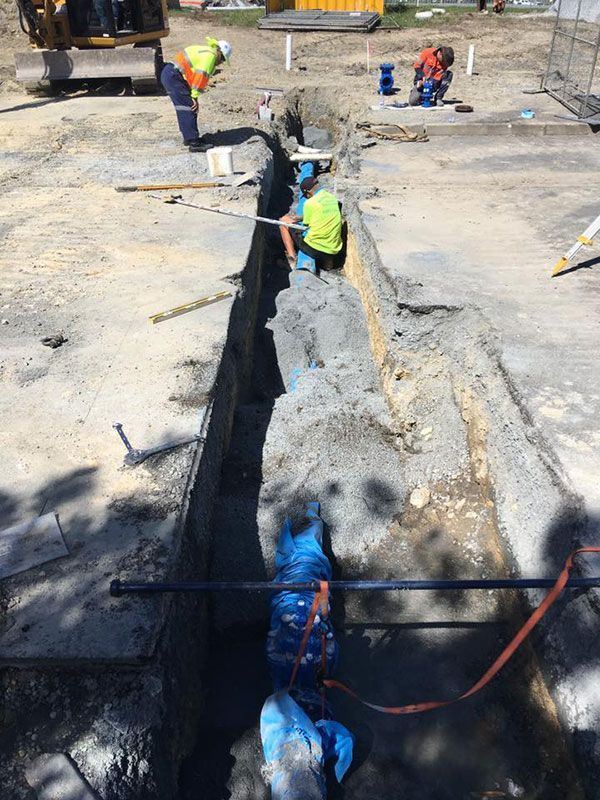 A group of construction workers are working in a trench.