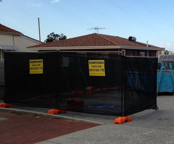 A black fence with yellow warning signs on it