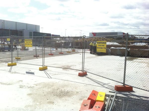 A construction site with a fence and a sign that says caution