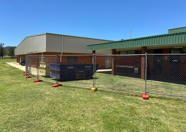 A chain link fence is in front of a building.