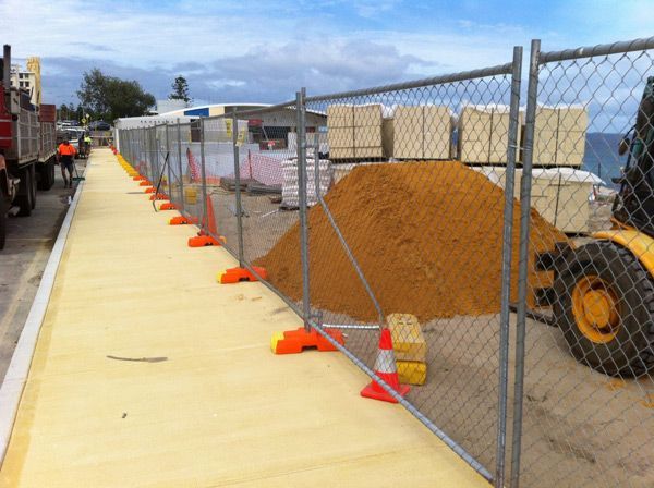 A construction site with a chain link fence and orange cones