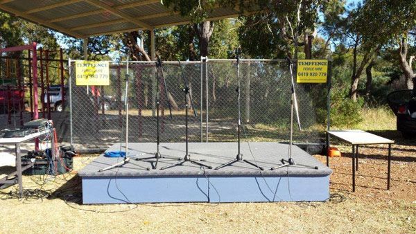 A stage with a fence and a table in the background