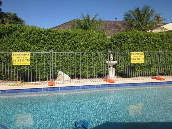 A fence around a swimming pool with a sign that says temptence