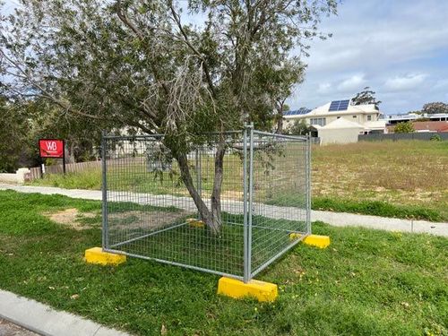 A fence with a tree in the middle of it.