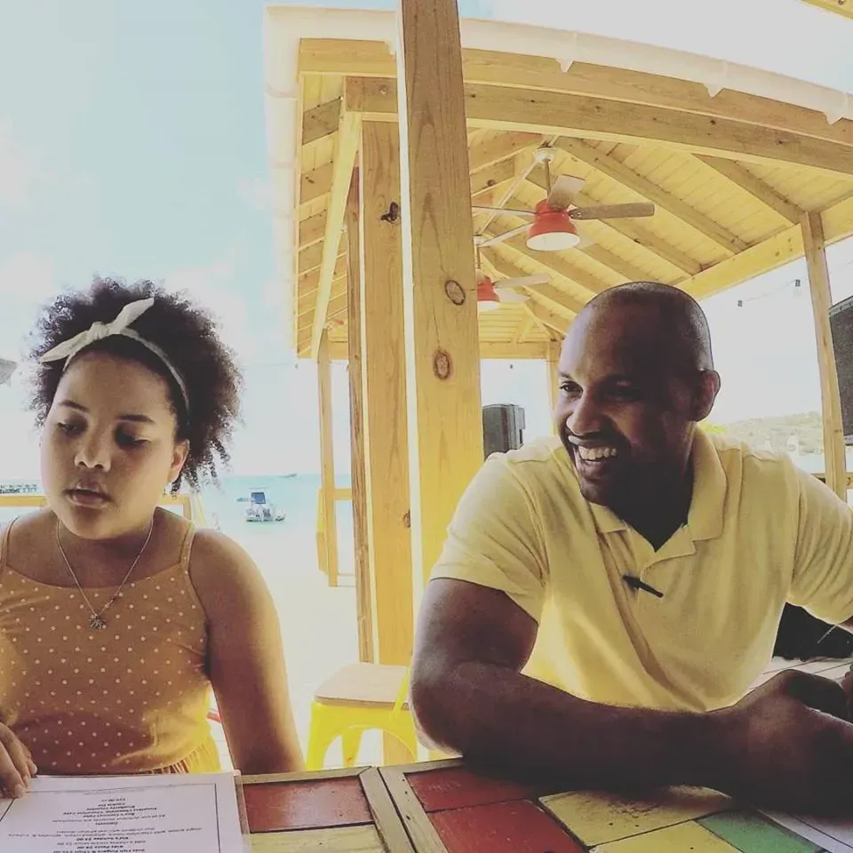 A man and a woman sit at a table under a canopy