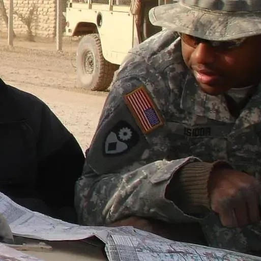 A man in a military uniform is looking at a map
