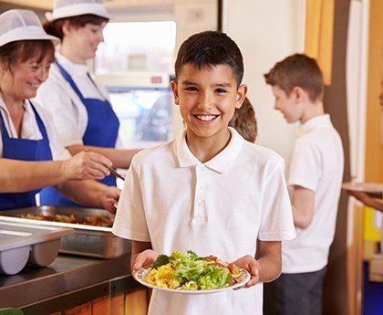 Boy Smiling Holding a Food — Exclusive Catering in Highland, IN