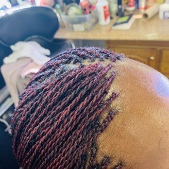 Close-up of a person's head with burgundy and black micro twists.
