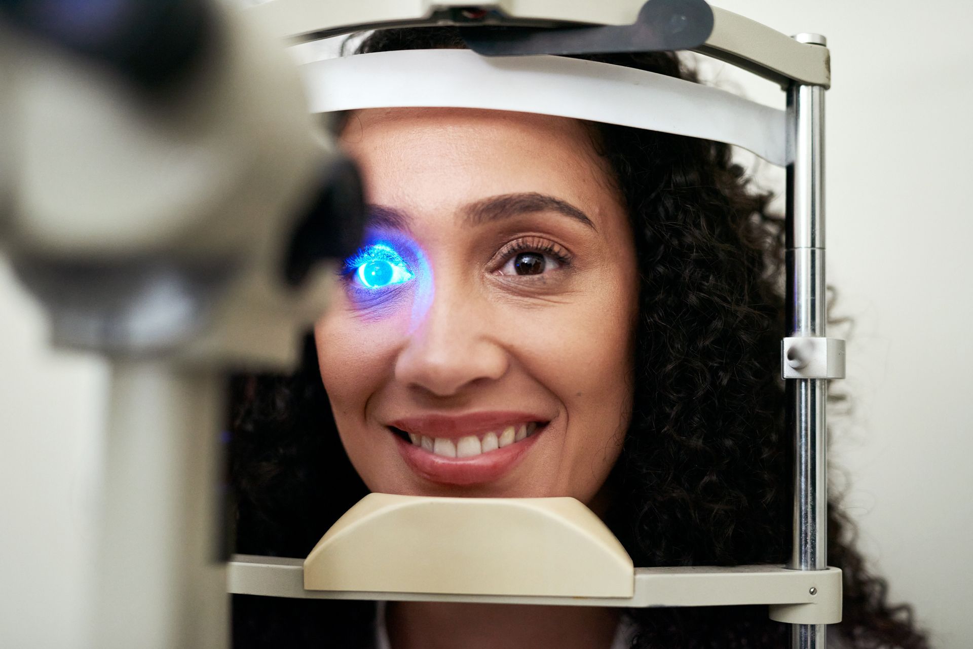 Woman in an eye vision test machine light. Woman in an eye vision test machine light.