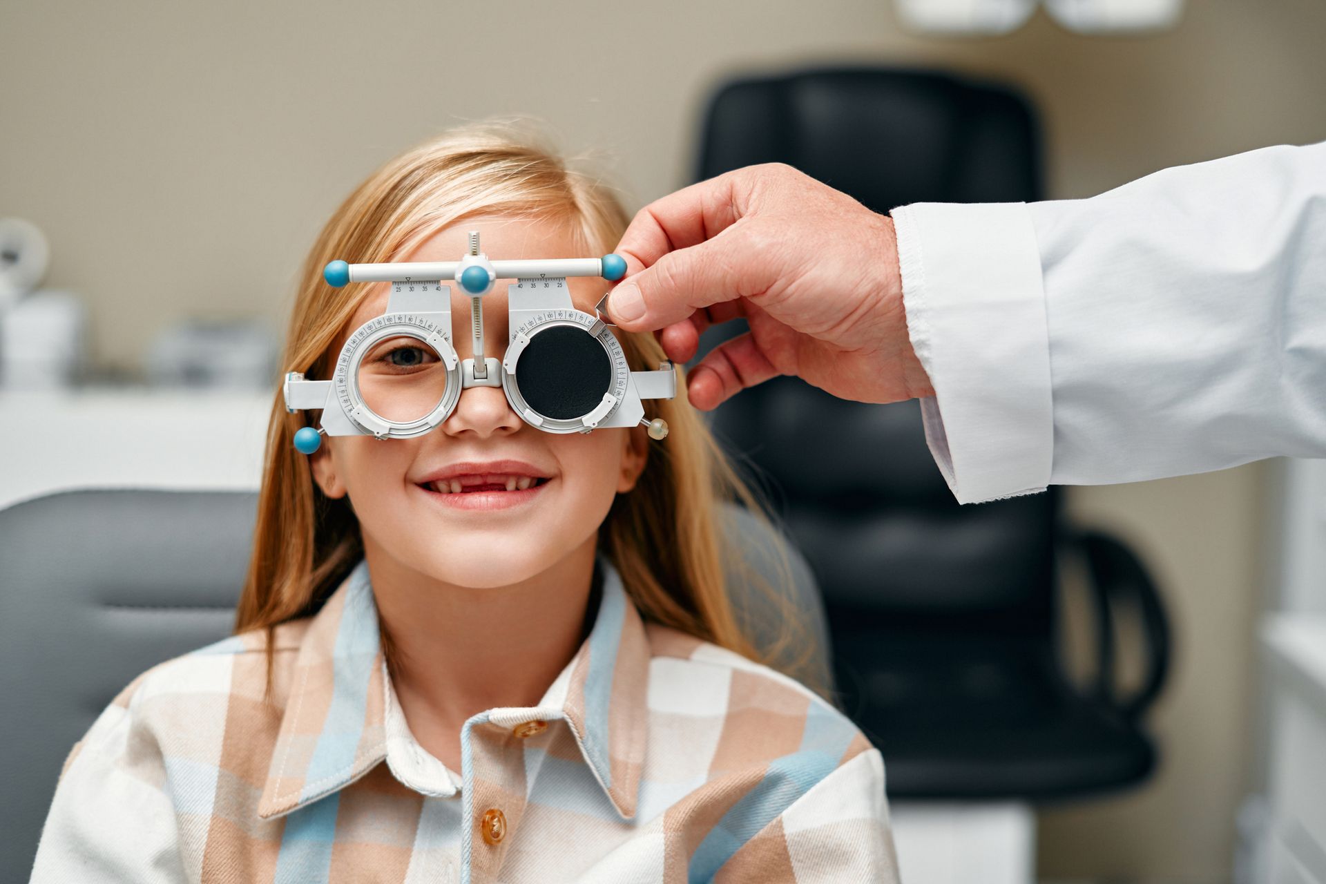 A doctor is examining a child 's eye with a pair of glasses.
