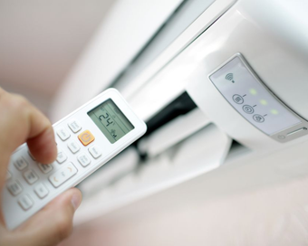 Hombre metiendo la mano en el compartimento superior de una habitación. Iluminación brillante y colores neutros.