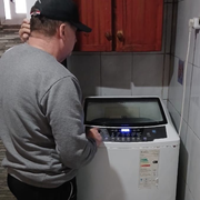 Hombre con gorra azul usando un destornillador en cables.